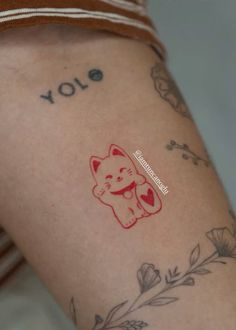 a woman with a tattoo on her arm has a red cat sticker on it