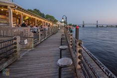 people are sitting at tables on the pier