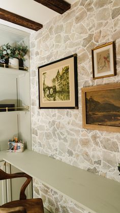 a room with stone walls and pictures on the wall