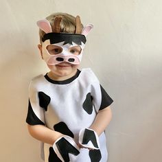 a little boy wearing a cow mask and dress