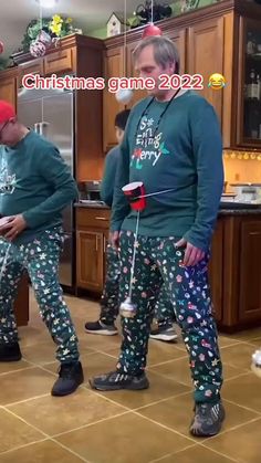 two men in matching christmas pajamas standing next to each other