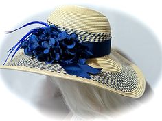 "This striking tan woven derby hat has bands of navy woven in the brim and crown. The wide brim measures 5\". The crown is wrapped in a navy rayon ribbon hat band with tails... all set on the side of the hat. A huge cluster of navy hydrangeas and a spray of royal biot feathers rest on the side of the crown. The hat measures 23\" with a tie pull in the inside band that can adjust the hat to fit. All of the pieces you see in my shop are my original designs and carefully crafted for your pleasure.. Girls Sun Hat, Hats Summer, Bridal Hat, Grass Valley, Tea Party Hats, Elegant Hats, Derby Hat, Church Hats, Sun Hats For Women