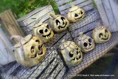 there are many carved pumpkins sitting on the bench together with faces drawn on them