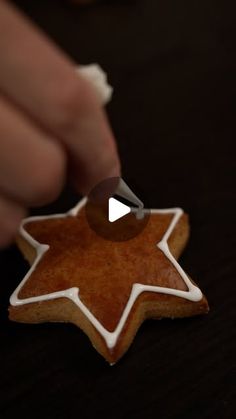 someone is decorating a gingerbread star with icing