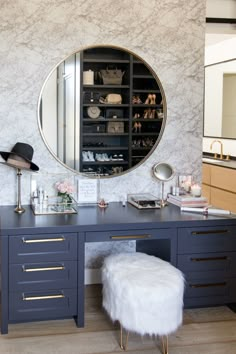 a vanity with a mirror and stool in front of it on a wooden floor next to a wall