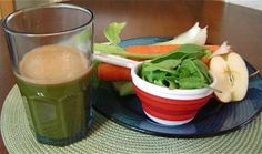 there is a bowl of vegetables and a glass of juice on the table with it