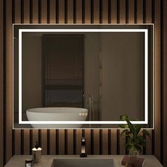 a bathroom with a sink, mirror and bathtub in the reflection on the wall