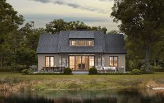 a house with a lake in front of it and trees around the outside area,