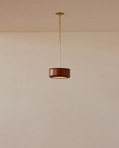 a light fixture hanging from the ceiling in a room with white walls and flooring