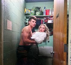 a shirtless man and woman standing in a bathroom