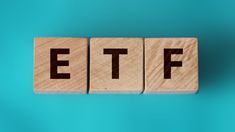 wooden blocks spelling the word etf on a blue background