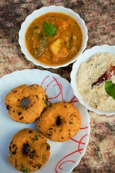 three plates filled with food on top of a marble counter next to a bowl of soup