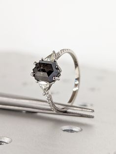 a diamond ring sitting on top of a piece of metal