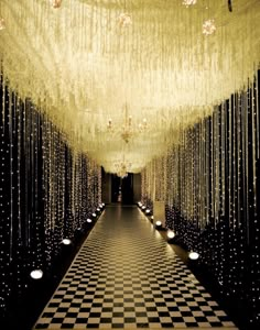 a black and white checkerboard floor with chandeliers hanging from the ceiling