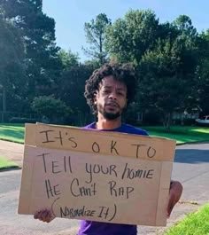 a man holding a sign that says it's ok to tell your home he can't rap