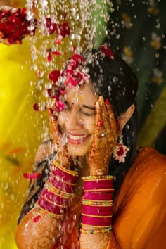 a woman with her hands on her face and arms covered in flowers, surrounded by water