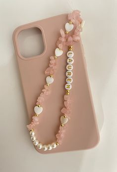 a pink phone case with pearls and flowers on it