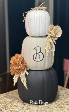 three pumpkins stacked on top of each other with the letter b painted on them