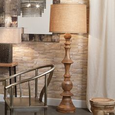 a wooden lamp next to a metal chair and table with a mirror on the wall behind it