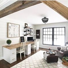 a living room filled with furniture and a white rug on top of a hard wood floor