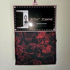 a sign hanging from the side of a wall that has skulls and roses on it