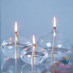 three candles are lit in clear glass dishes