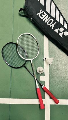 two tennis racquets and a badminton racket on a court