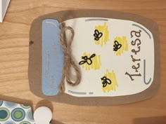 a close up of a paper tag on a wooden table with scissors and other items