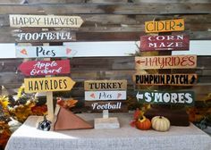 a table topped with wooden signs and pumpkins