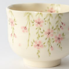 a white bowl with pink flowers painted on it