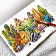 a card with colorful leaves on it next to a pencil and paper clippings