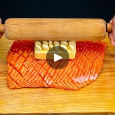 someone is holding a rolling board with raw fish on it, and the video shows how to make sushi rolls