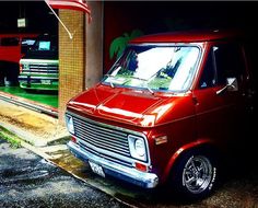 an old red truck parked in front of a building