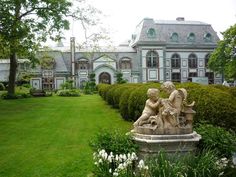 a statue in front of a large house