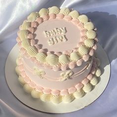 a pink and white birthday cake with the words happy life on it's side