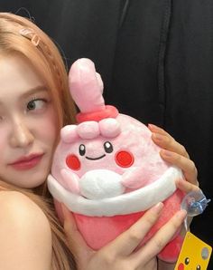 a girl is holding a stuffed toy in her hands and smiling at the camera while she holds it up