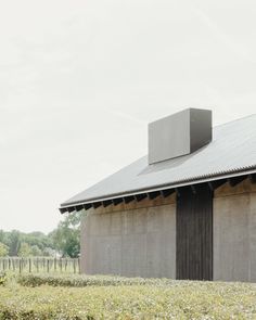 an old barn with a metal roof and two large rectangular boxes on the top of it