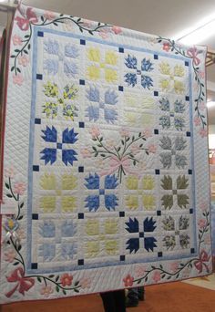 a quilt is displayed on a stand in a store