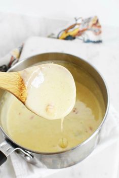 a wooden spoon is being used to stir food in a saucepan on the stove