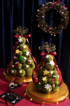 two green christmas trees with decorations on them