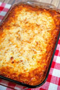 a cheesy casserole dish with cheese and herbs in it on a checkered table cloth