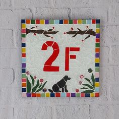 a sign on the side of a building that says 2f with a dog sitting in front of it