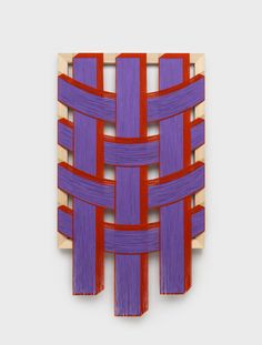 a piece of art made out of wood with red and purple strips on it's sides