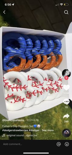 a box filled with blue and orange plastic baseballs on top of a grass covered field