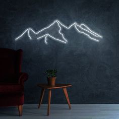 a chair and table in front of a wall with mountains on it