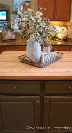 a kitchen island with flowers in a vase on it