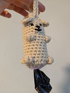 a crocheted stuffed animal hanging from a string with a bag on it's end