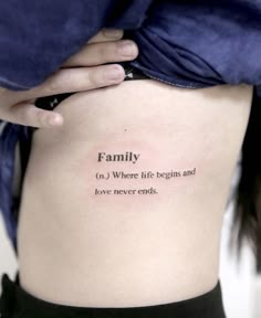 a woman's lower back tattoo with the words family on it