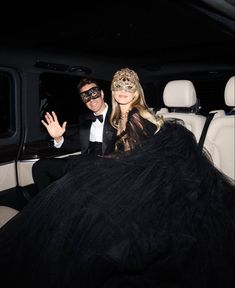 a man in a tuxedo and a woman wearing a mask