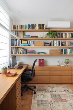 a home office with bookshelves, desk and computer on the far wall in front of it